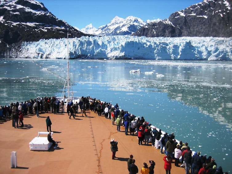 Cruise ship, crowds lining the railings.