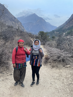 Two women pictured outside in front of mountains.
