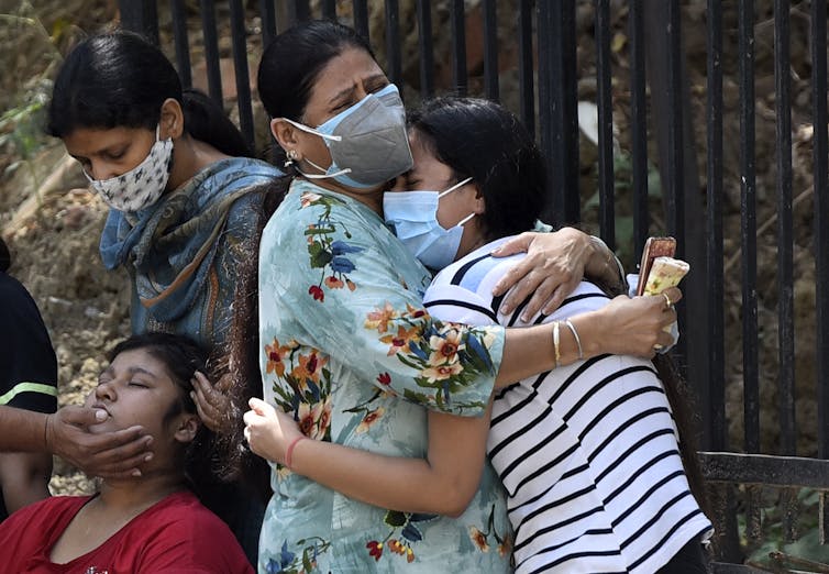 Grieving women hugging one another.