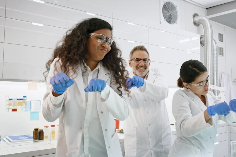 Three lab workers dancing.