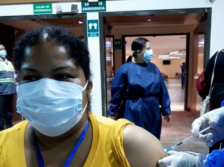 A woman receiving a vaccine in Ecuador.