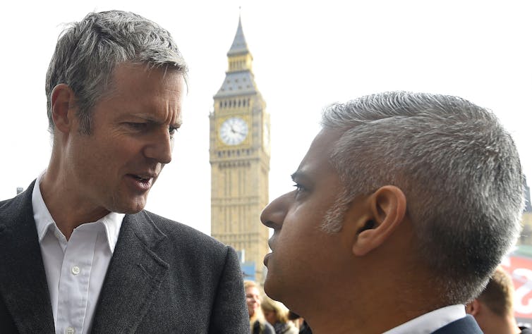 Zac Goldsmith and Sadiq Khan look at each other in front of the Palace of Westminster.