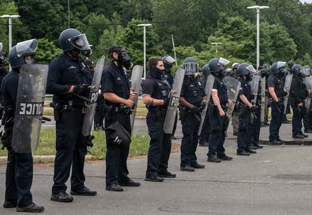 A line of police with shields, masks and helmets, as protesters marched against police brutality in Detroit, Michigan in 2020.