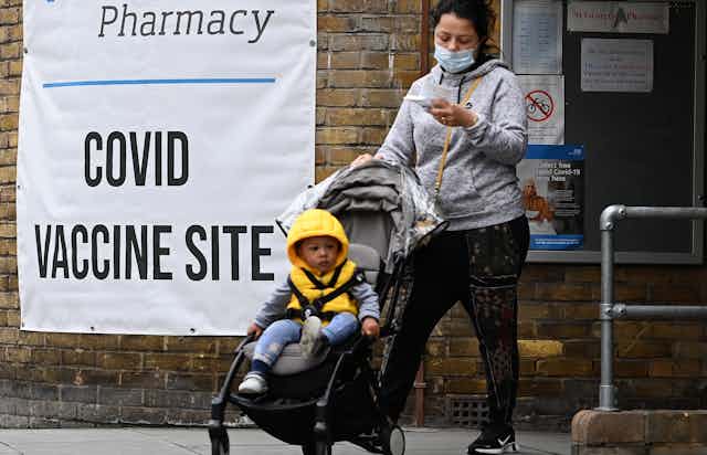 A woman and her child in a buggy leaving a COVID-19 vaccine centre