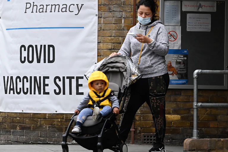 A woman and her child in a buggy leaving a COVID-19 vaccine centre