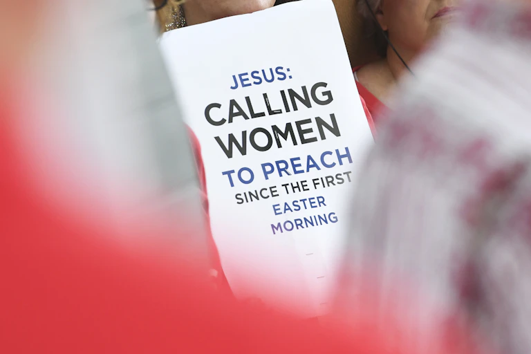 A poster saying 'Jesus: Calling women to preach since the first Easter morning,' is held up by protestors outside a Southern Baptist Convention annual meeting in 2019.