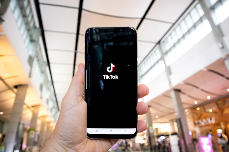 Person holding a phone with TikTok app opening