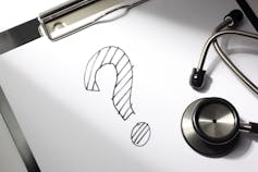A question mark on a piece of paper next to a stethoscope.