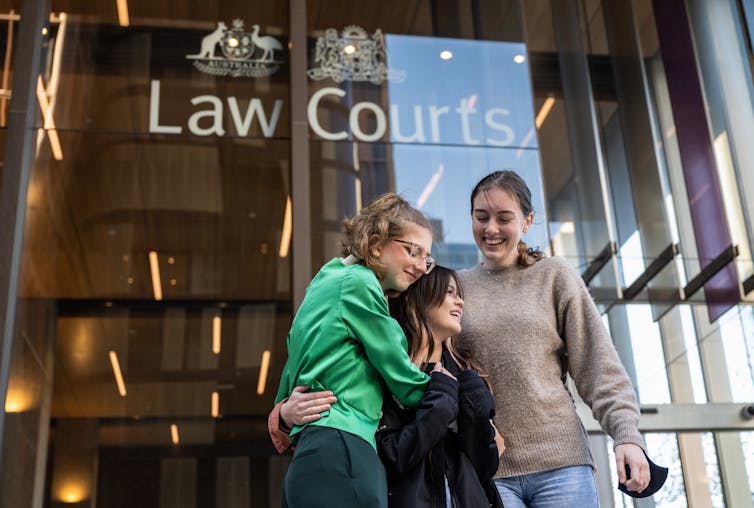 Three teens involved in the case embrace outside the Federal Court