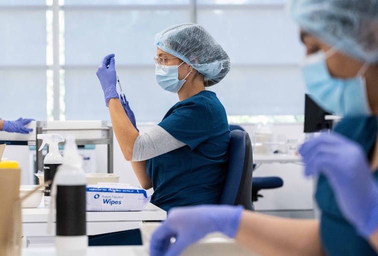 Staff preparing COVID-19 vaccines.