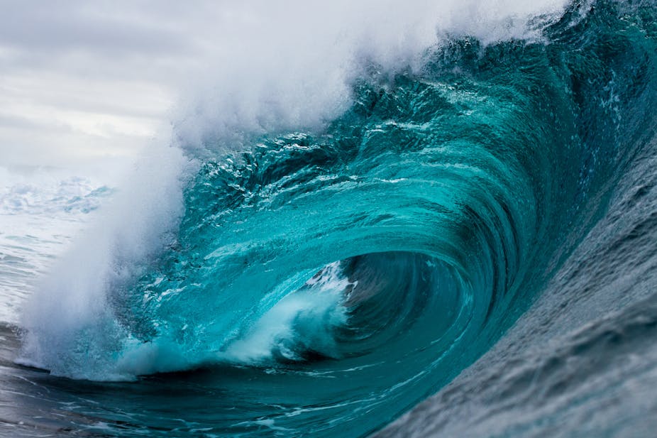 Inside the barrel of a large, crashing ocean wave.