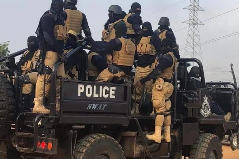 Masked, armed men in an armoured police vehicle
