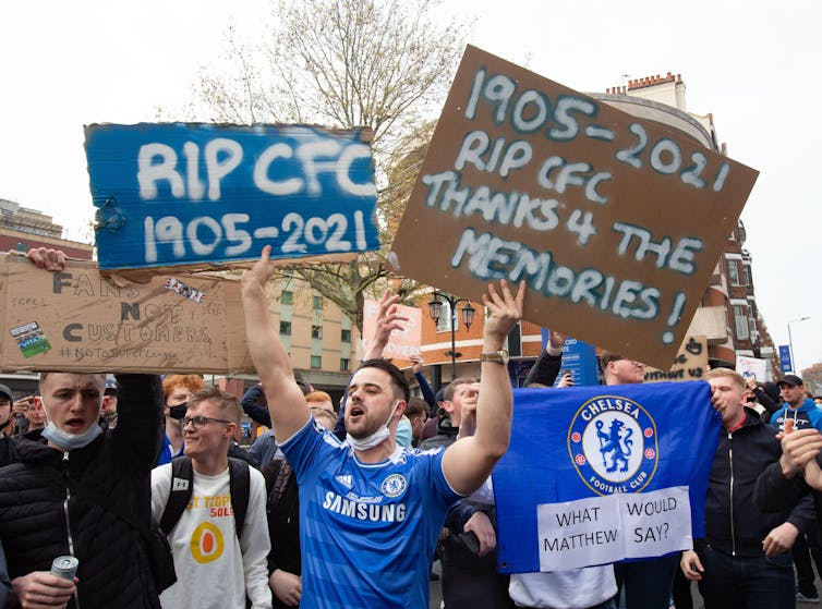 Chelsea fans holding anti-Super League placards.