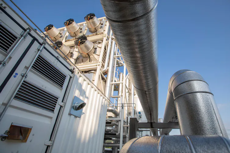 Metal pipes connected to a large array of industrial fans.