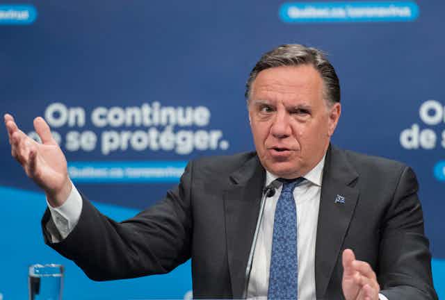 Legault gesture at a news conference.