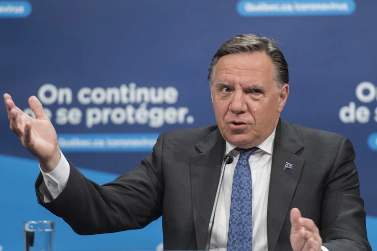Legault gesture at a news conference.