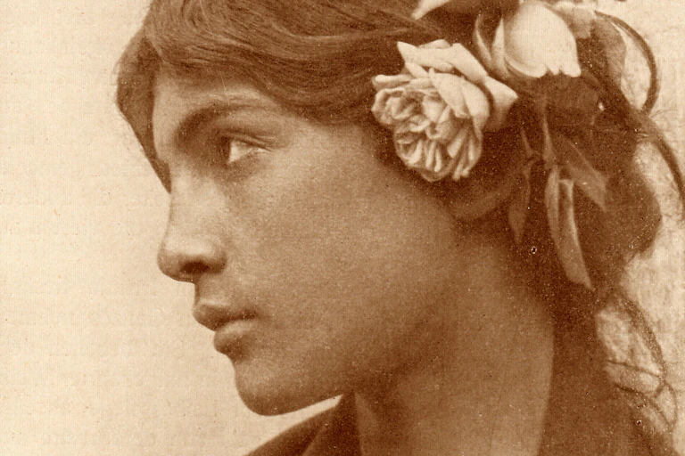 A boy wears a wig with flowers affixed to it.