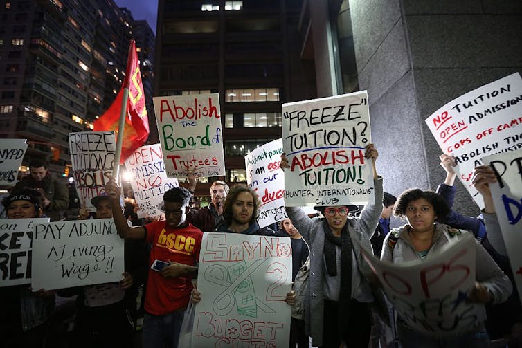 Students hold placards  saying 'Abolish tuition' during a demonstration for tuition-free public colleges in New York City.