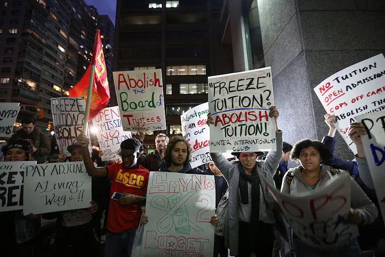 Students hold placards saying 'Abolish tuition' during a demonstration for tuition-free public colleges in New York City.