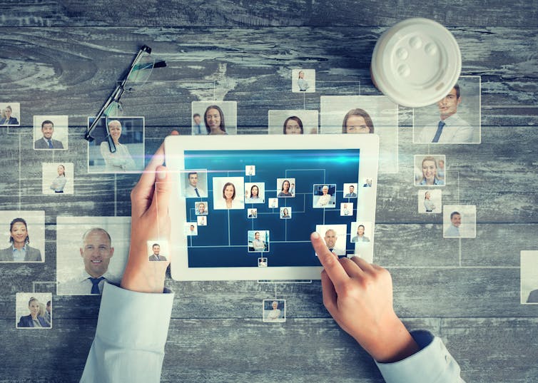 Ipad shows images of multiple people in a web to illustrate a social network