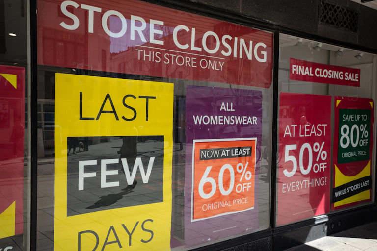 Department store window with posters indicating imminent closure.