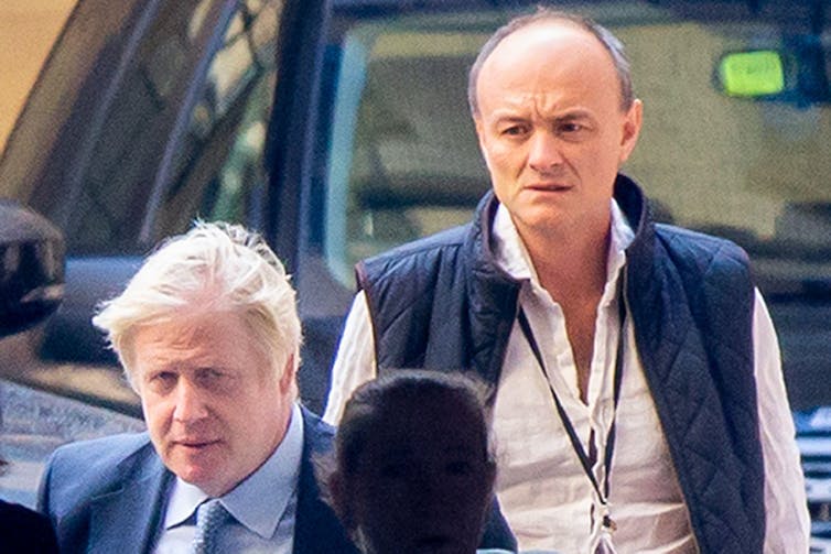 Boris Johnson and Dominic Cummings stood in front of a car