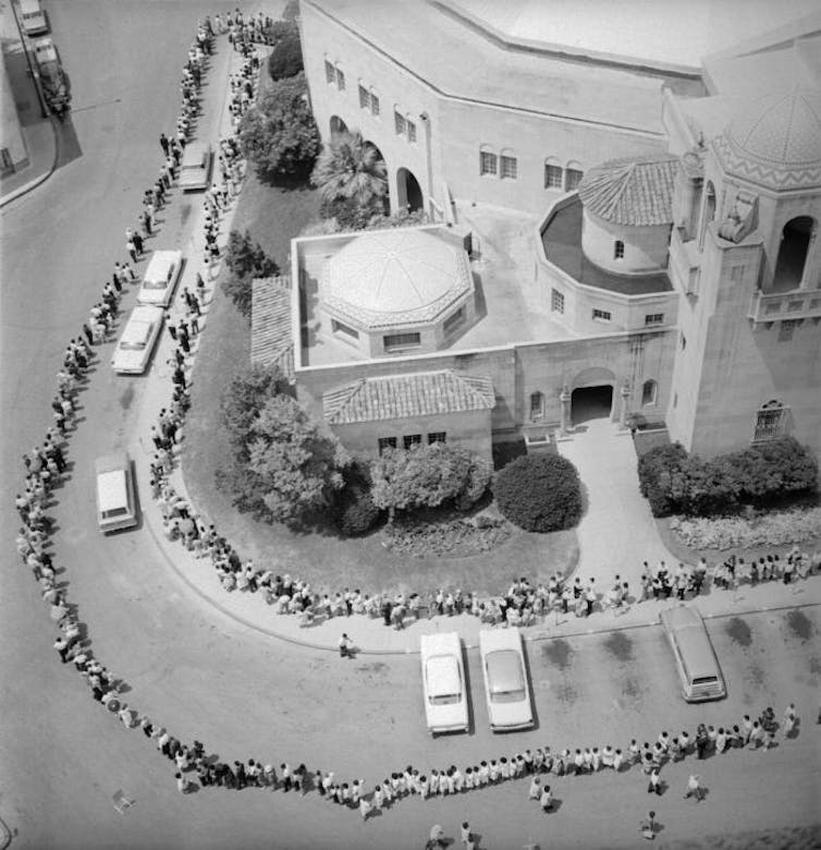 This historic 1962 image depicted an aerial view of a long line of people awaiting their polio vaccination. The line was so long, it surrounded a city auditorium in San Antonio, Texas.