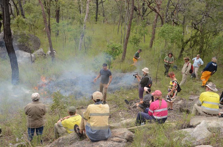 A few people surround a small fire