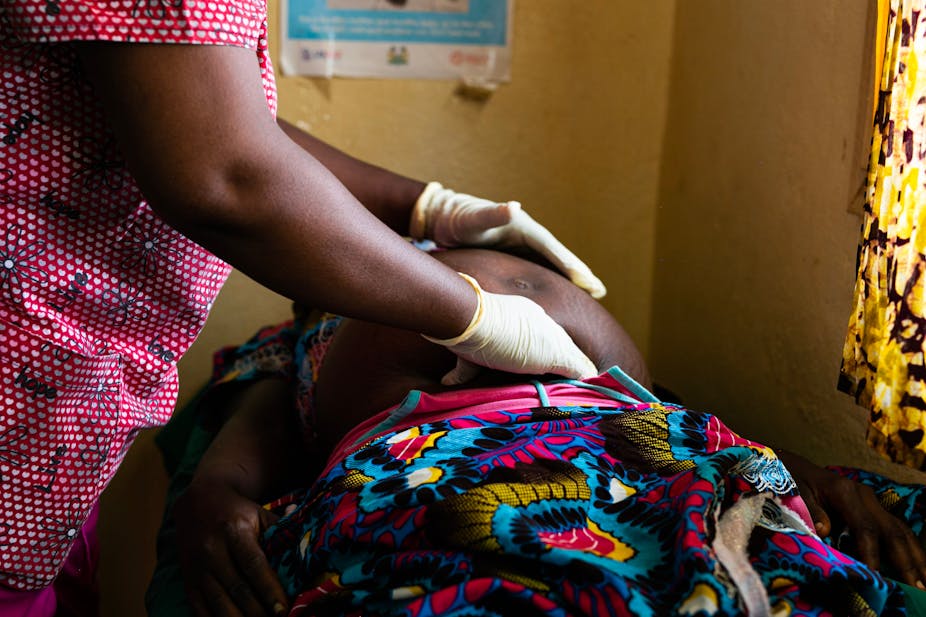 Female doctor examines a pregnant woman's stomach