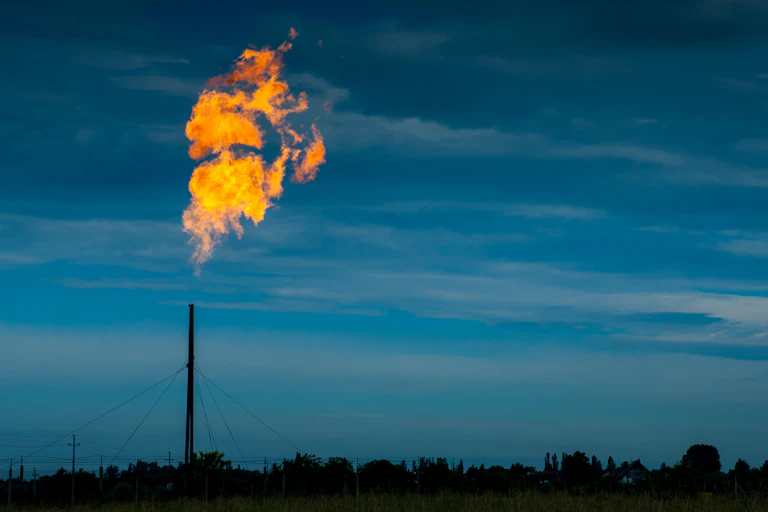 Huge flames coming out from a tall gas pipe maintenance on gas distribution site