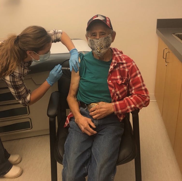 An Indigenous man gets a vaccinne in his right arm