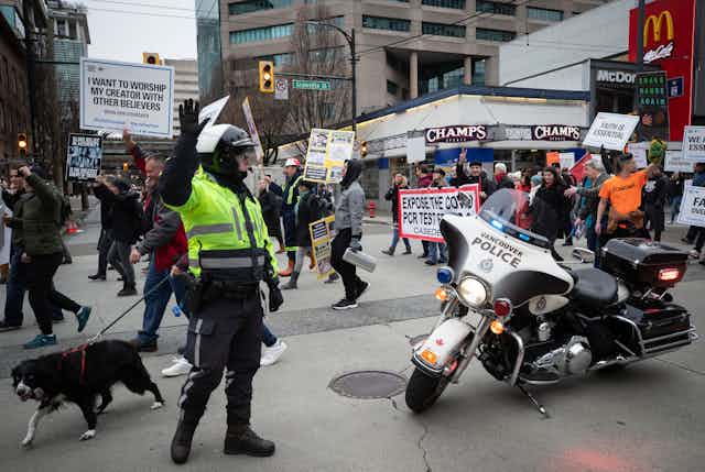 Police officer stops traffic as protesters march behind