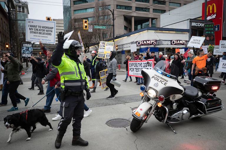 Police officer stops traffic as protesters march behind