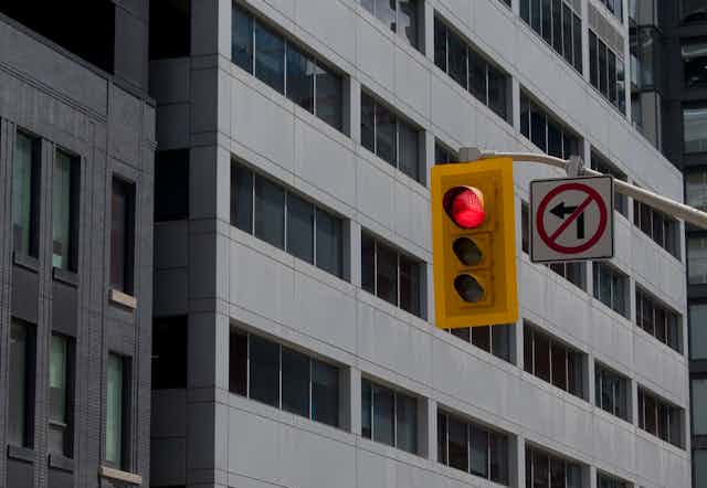 A traffic light with a no left turn sign in a city.