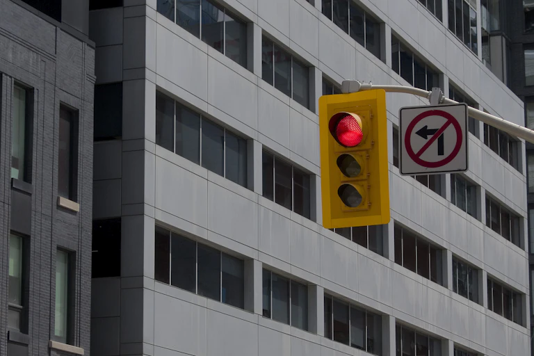 A traffic light with a no left turn sign in a city.