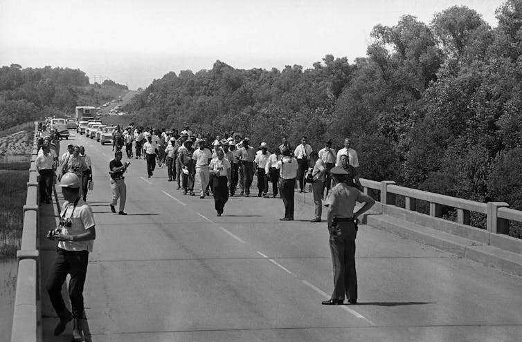 A group of marchers on a highway in northern Mississippi, including civil rights leaders Martin Luther King Jr., Stokely Carmichael and Floyd McKissick.