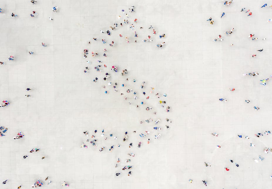 People arranged into the shape of a dollar sign