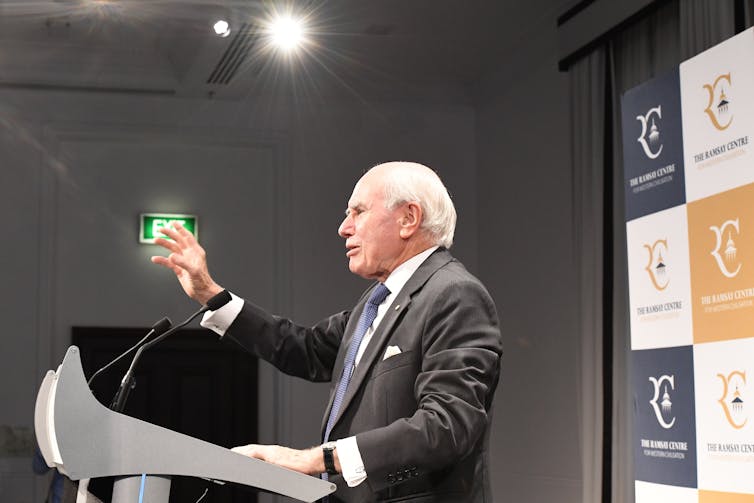 man in suit delivers a speech at a lectern