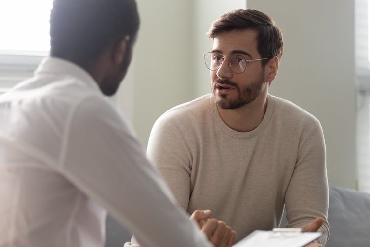 A young man talks with a clinician.