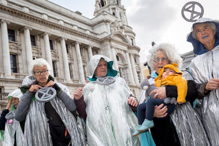 People in grey with XR signs with baby