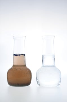 Two glass vials, one containing brown dirty water and the other clean clear water.