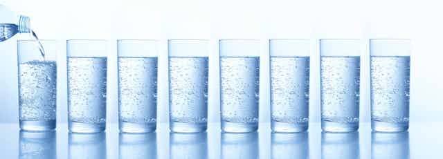 A line of glasses filled with water. 