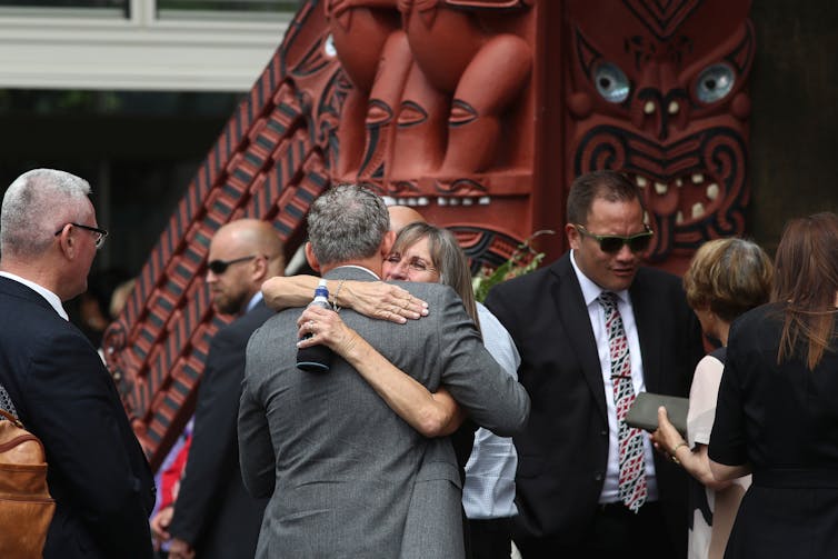 People gathering for a memorial service one year after the eruption of Whakaari White Island.