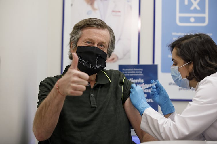 John Tory getting an injection, giving a thumbs-up