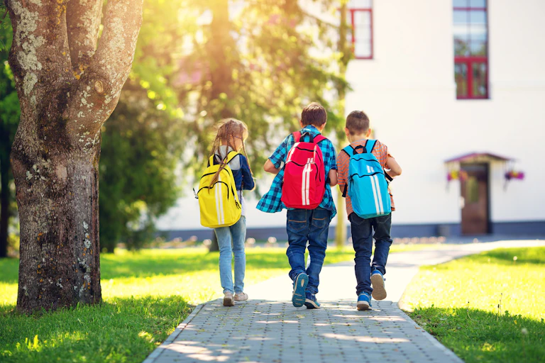 Kids walking to school with green space around them.