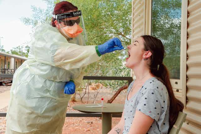 Health worker in PPE taking COVID test at Howard Springs quarantine facility