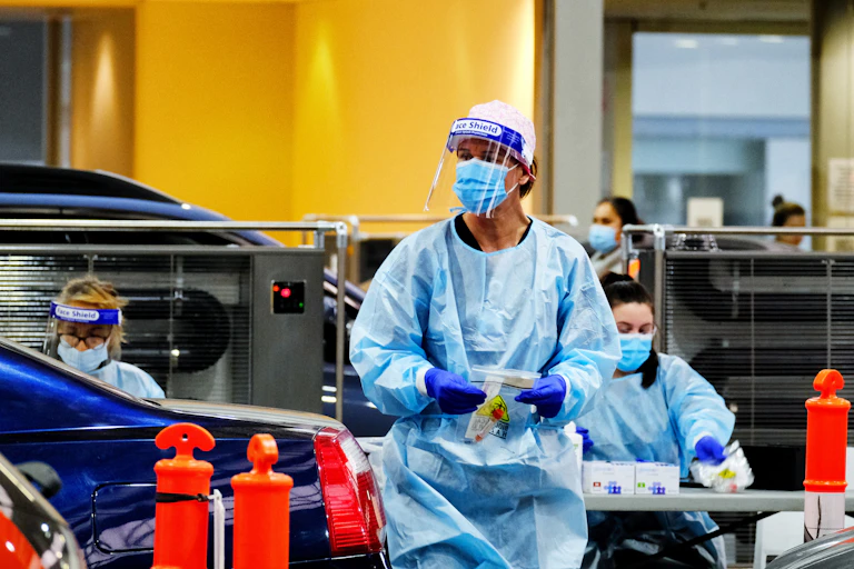 A health-care worker holds a COVID test kit at a Melbourne testing site.