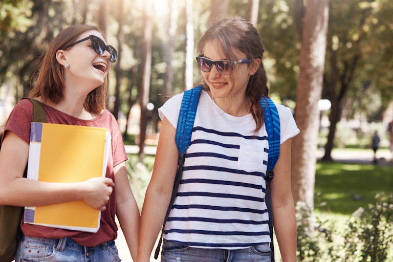 Two schoolgirls holding hands.