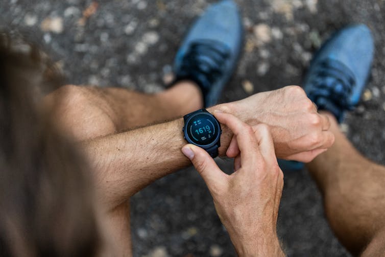 A man adjusts his smartwatch.