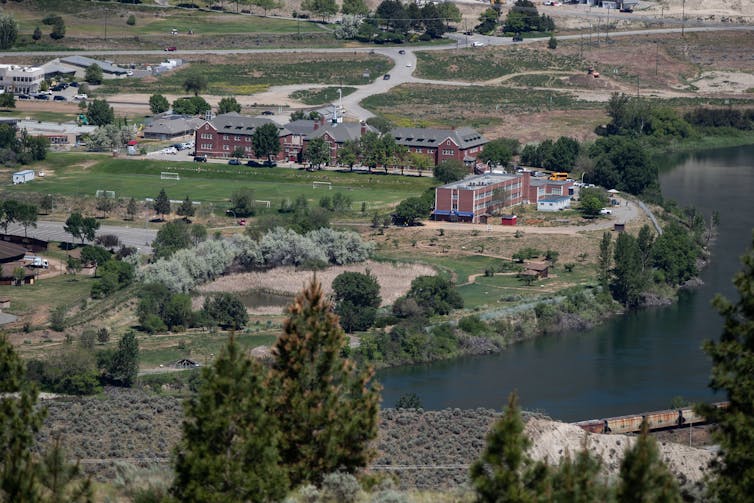 An aerial photo of the school that is set along a winding river